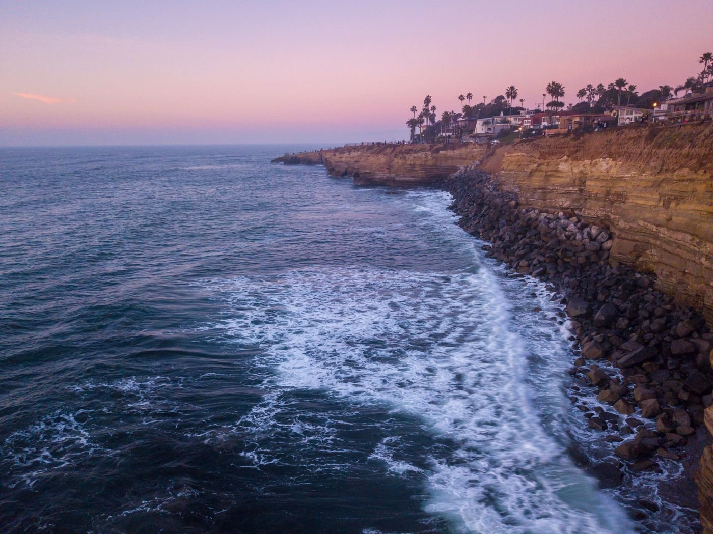 An aerial view of the coastal cliffs at Sunset Cliffs in San Diego with waves breaking below