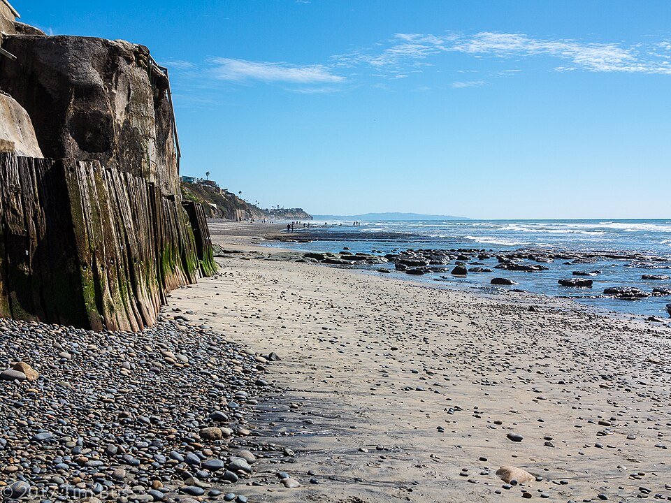 A cobble and sand beach with a rocky cliff at Beacon's Beach in Encinitas