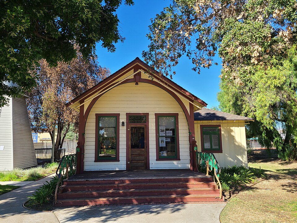 The small yellow Victorian building that was Escondido's first library, with red steps and shade trees