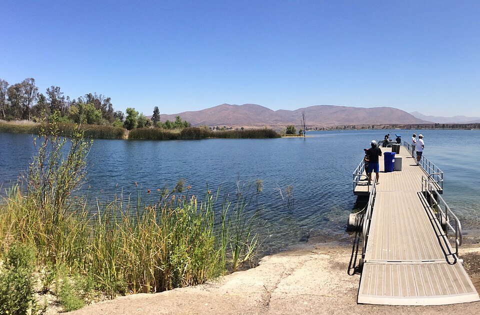 A floating fishing dock reaching into Lower Otay Reservoir, with hills across the water