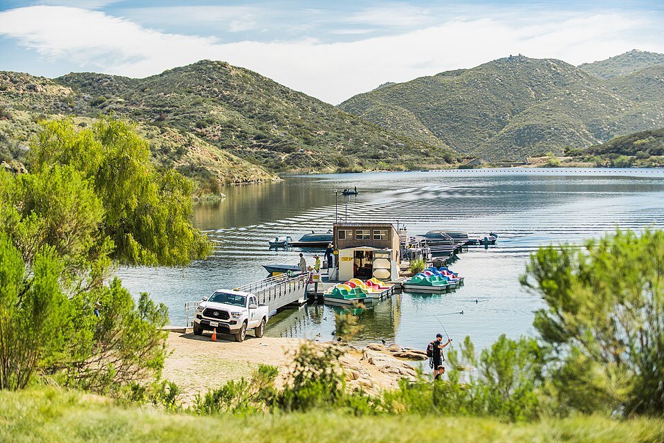 Pedal boats and a boat dock on Dixon Lake with green hills beyond
