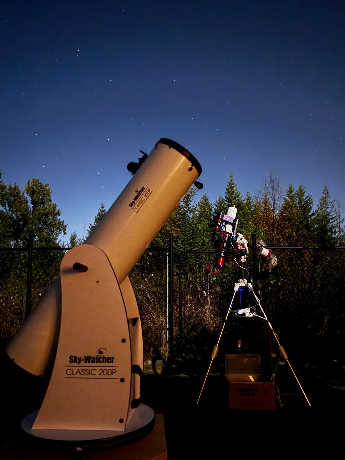 Telescopes set up under a night sky full of stars