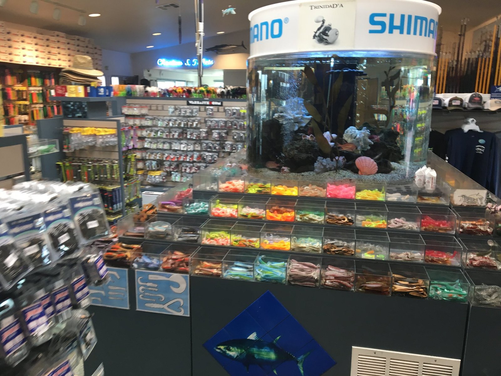 Inside a Point Loma tackle shop, with a round tuna aquarium, bins of soft plastic lures and rods on the wall