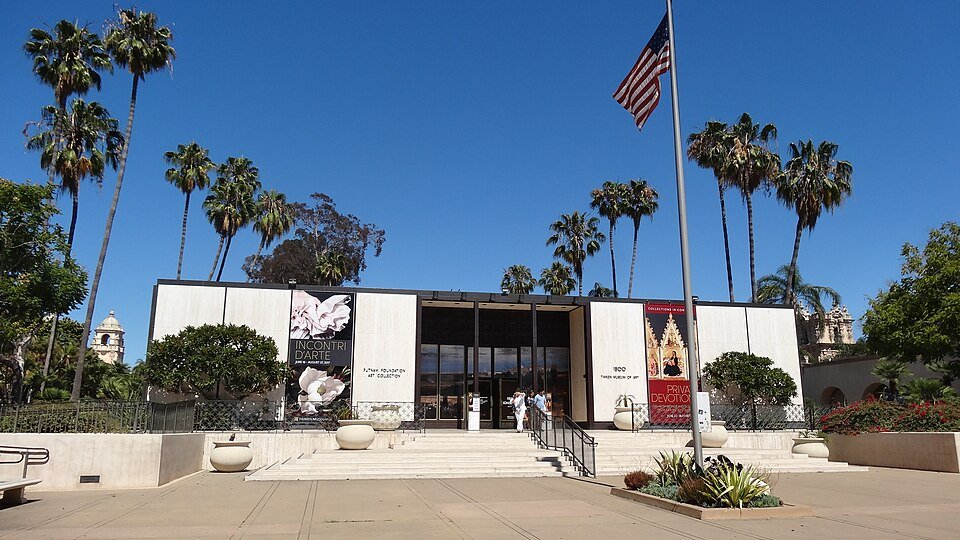 The low modern Timken Museum of Art building with a flagpole and palm trees